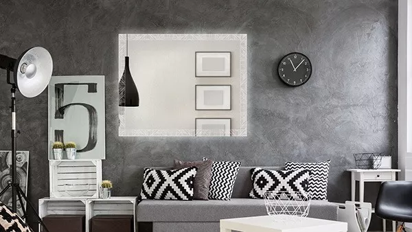 A living room with a nice couch, a stylish chair, and a decorative front lit mirror in Adelaide.