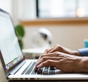 A man in Adelaide typing on a laptop keyboard.