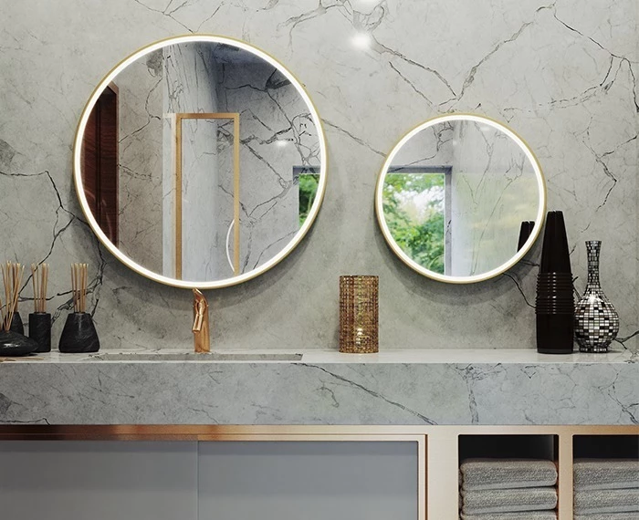 Adelaide luxurious bathroom with elegant marble walls and a stunning circular gold mirror.