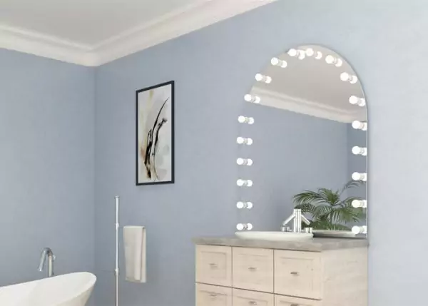 Arch shaped hollywood mirror mounted on a light blue wall in a bathroom in Newcastle.