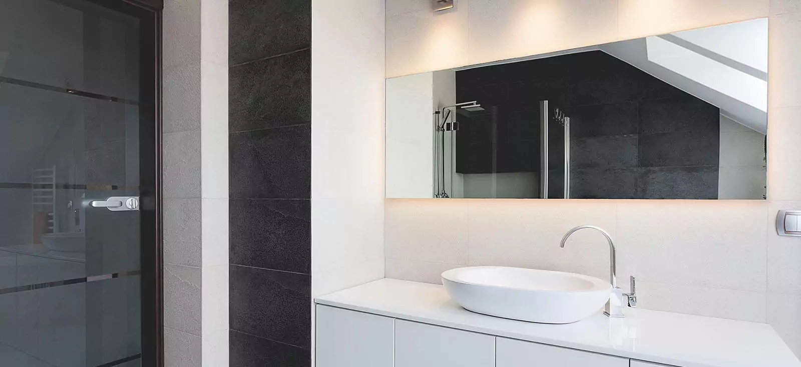 Image of a contemporary bathroom with a white sink and a custom lighted mirror in Brisbane.