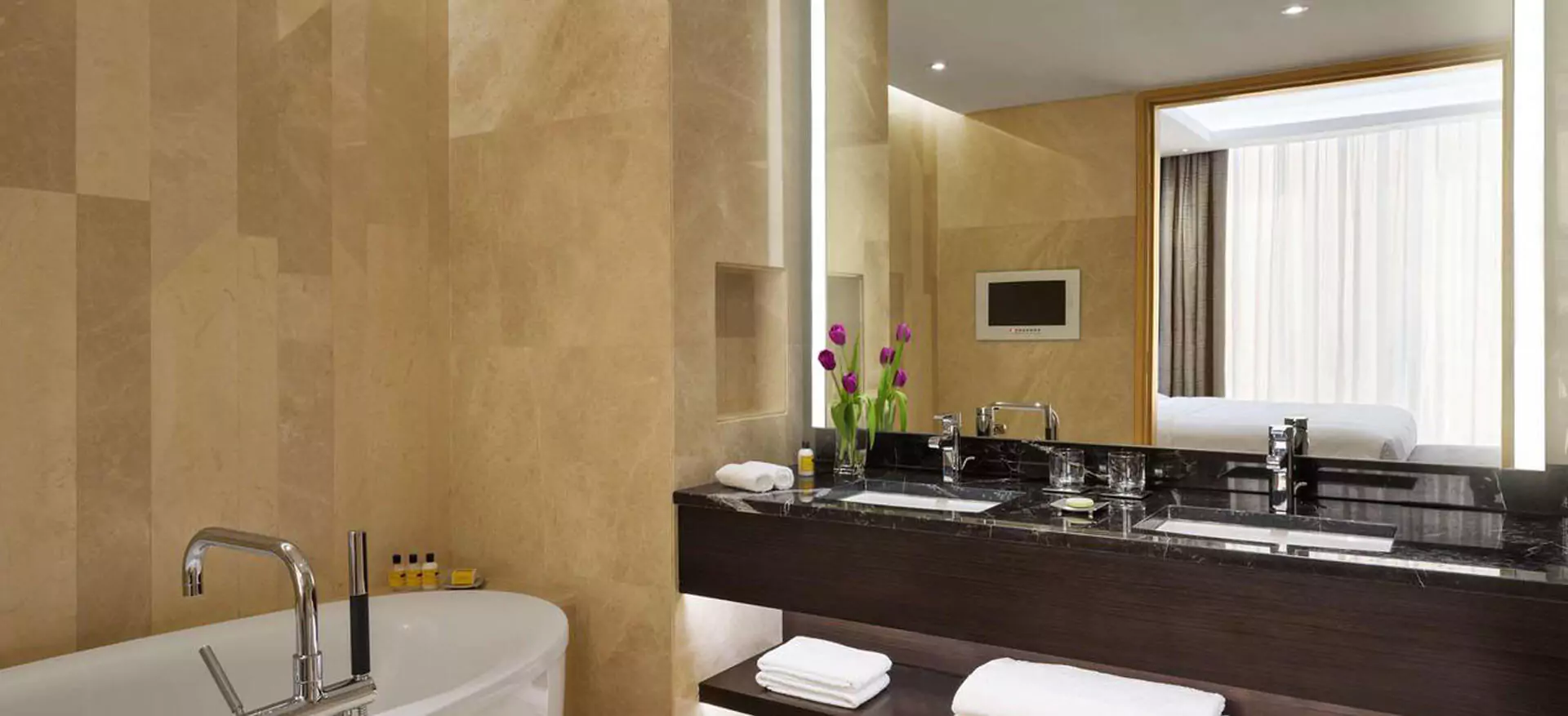 A luxurious bathroom in Gold Coast featuring a spacious tub and a bespoke lighted mirror.