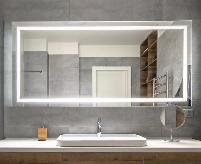 Clean and minimalist bathroom in Brisbane with a sink and a large rectangle lighted mirror.