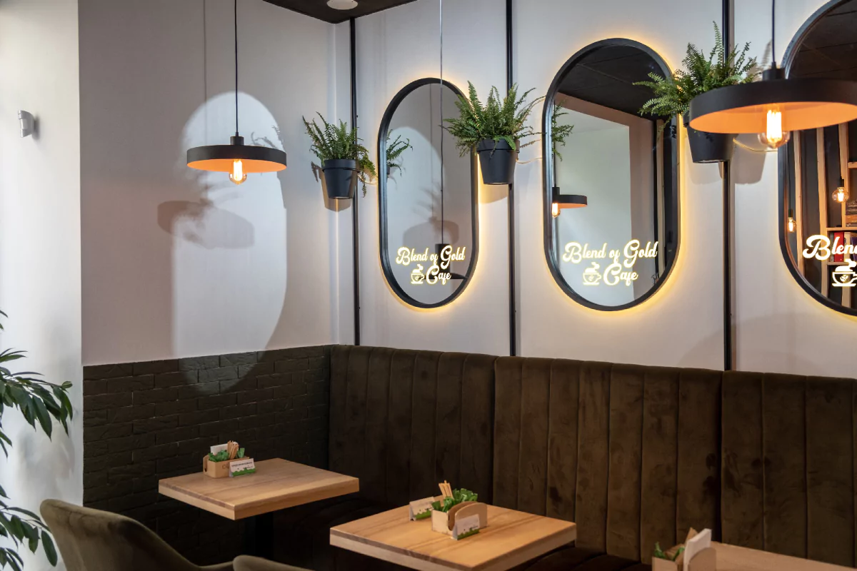 Cozy restaurant with wooden walls and large mirrors featuring LED light logos in Perth.