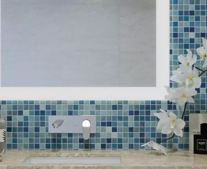 A bathroom with blue and white tiles, featuring made to measure mirror in Darwin.