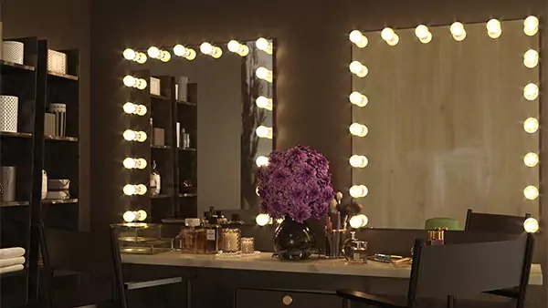 Hollywood style lighted mirrors, beauty products, purple flowers, and two directors chairs in Darwin.