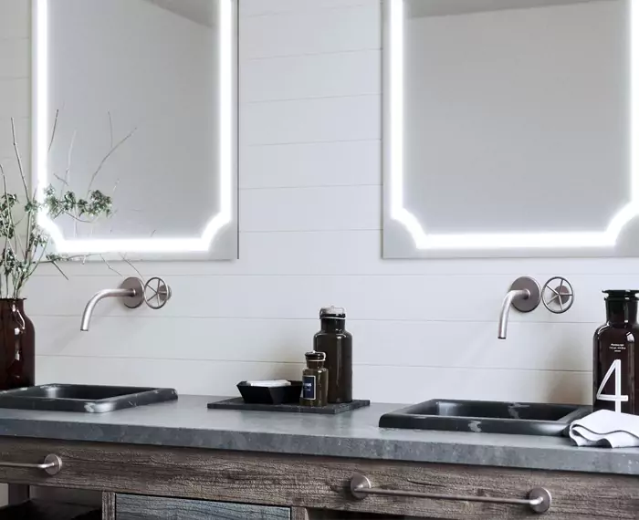 Double sinks with wall hung lighted mirrors in a modern washroom in Melbourne.