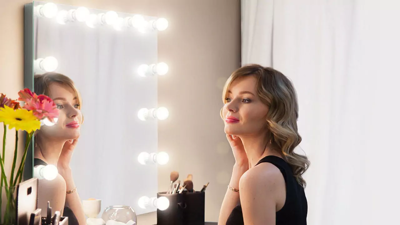 A joyful woman gazes at her reflection in a hollywood mirror in Hobart.