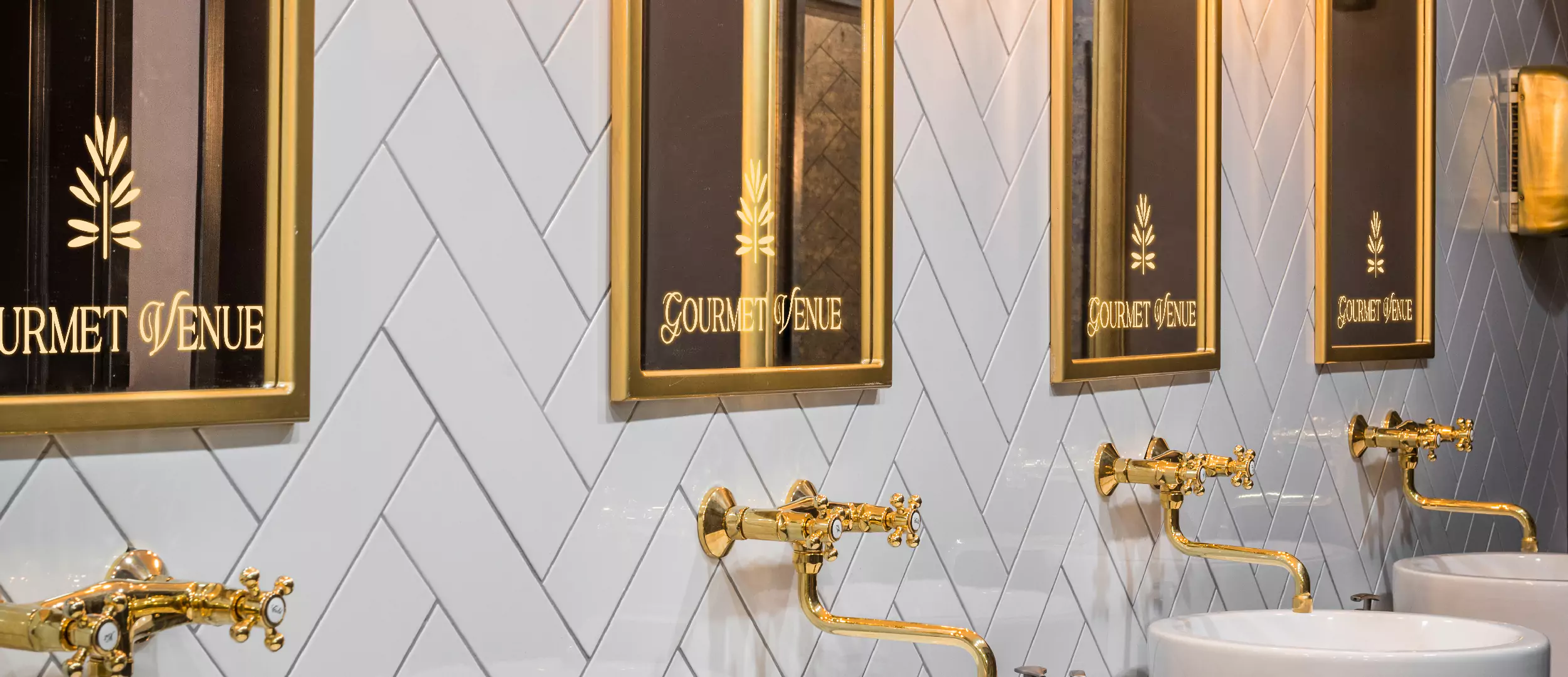 Luxurious bathroom featuring gold framed mirrors with lighted logos in Melbourne.