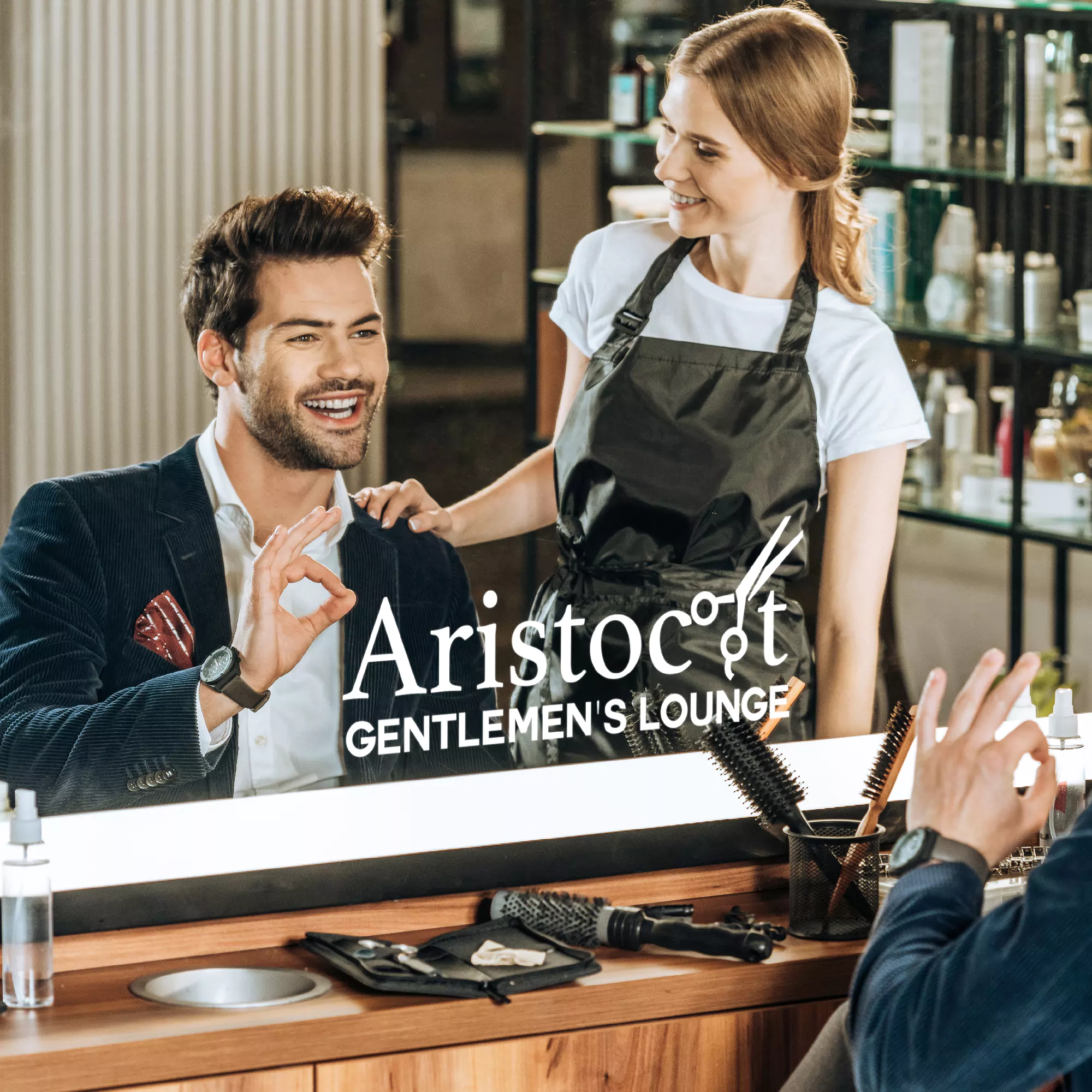 Reflection in a logo mirror of a man and a mane master admiring his hairstyle in an Aristocut shop.