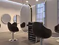 Icon of two oval salon mirrors with lights and a trolley positioned between them in Hobart.