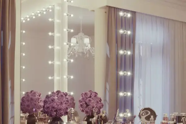 Hollywood mirror above a compact table with cosmetics placed on its surface in Newcastle.