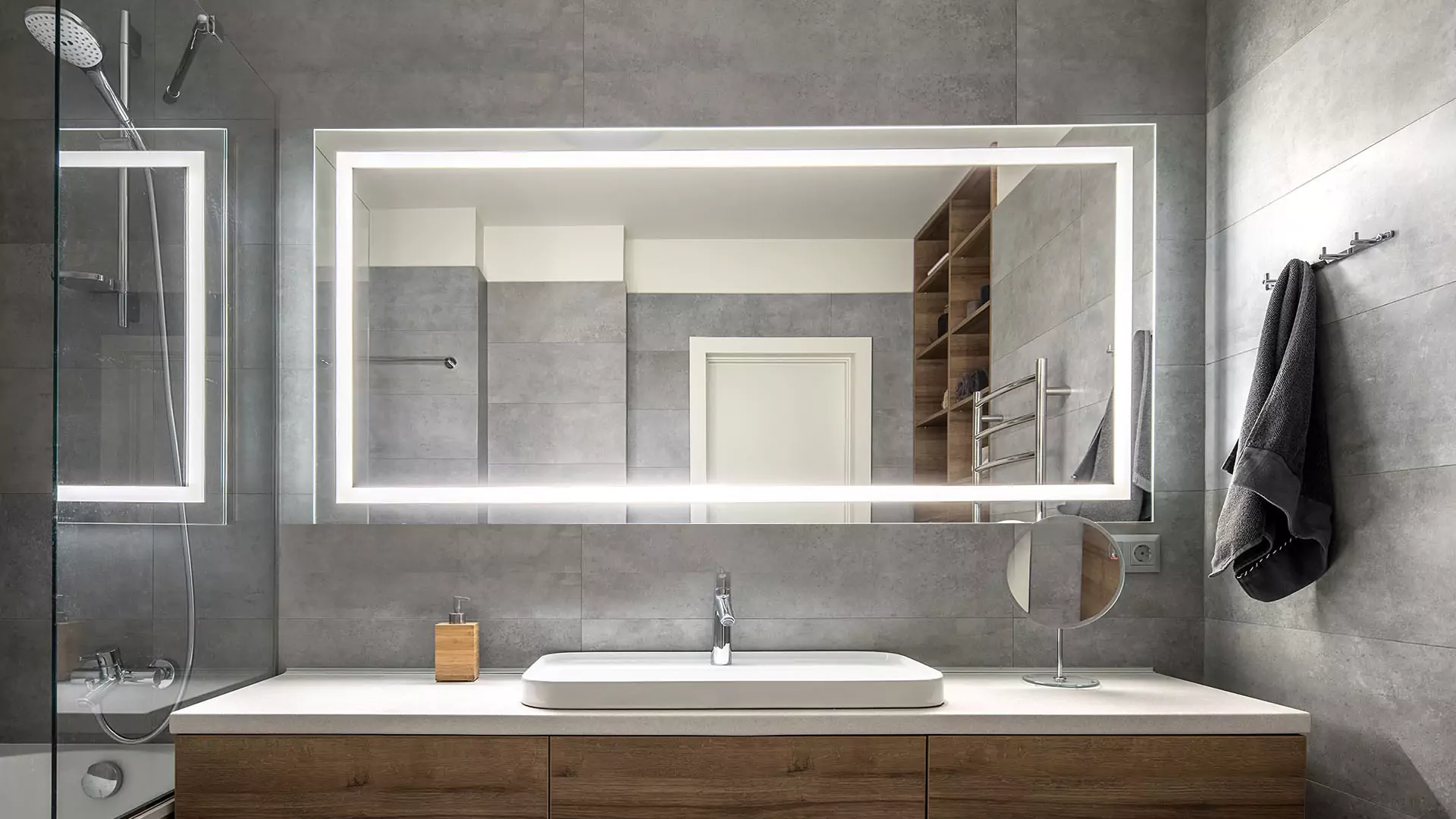 Lavish bathroom showcasing a large sized lighted mirror and a sink in Queensland.