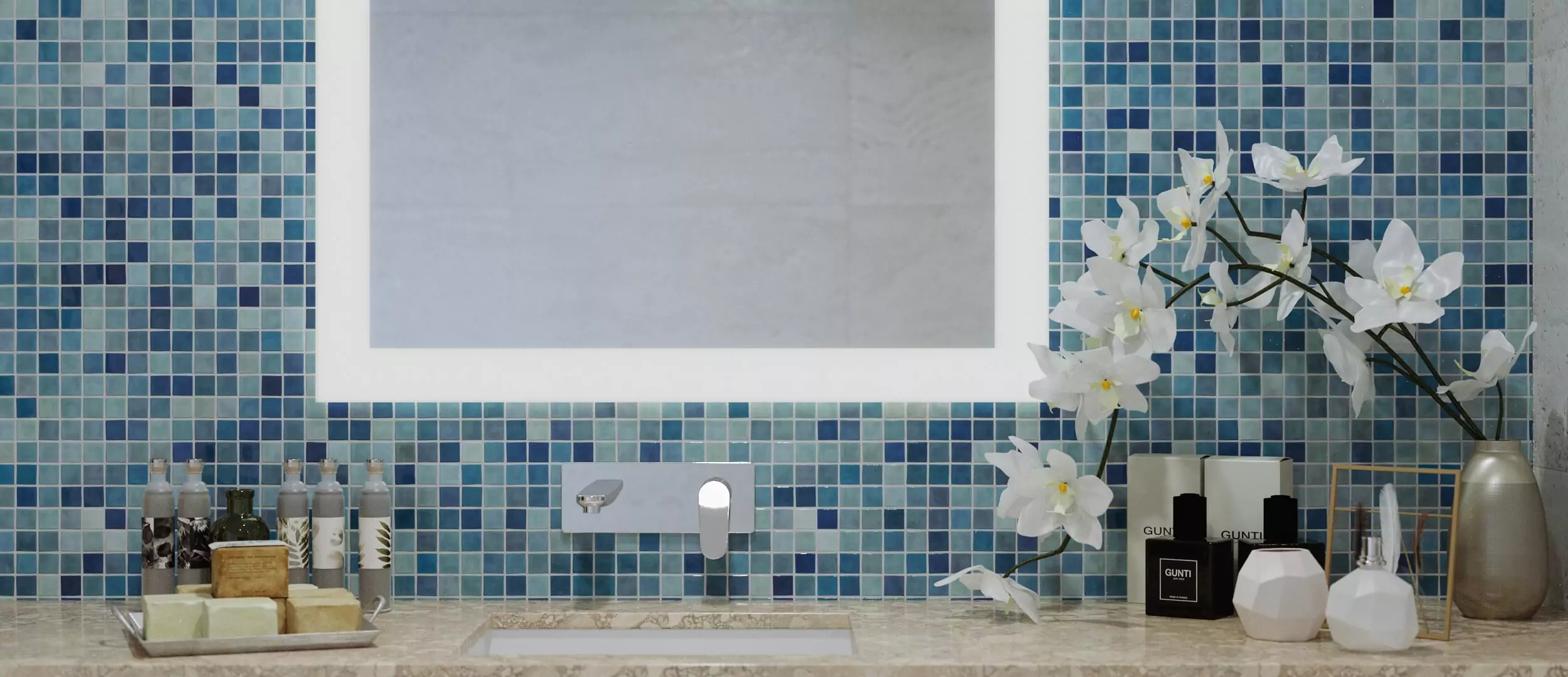 A bathroom with a lighted mirror and a blue mosaic wall in Canberra.