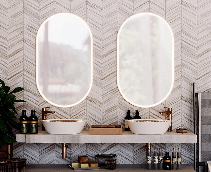 A Lismore contemporary bathroom featuring dual sinks and oval aluminium framed mirrors.