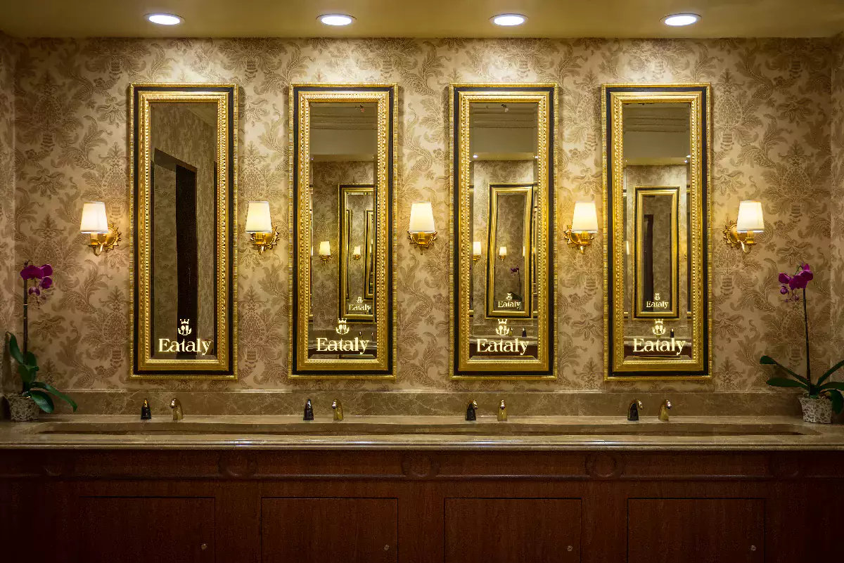 Luxurious bathroom showcasing mirrors with gold frames, and customized lighted logos in Wellington.