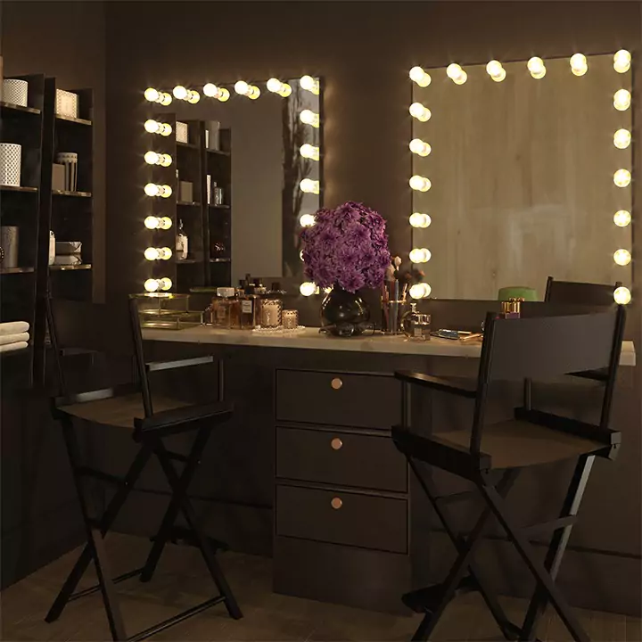 Vanity with hollywood lighted mirrors, purple flowers, and two directors chairs in Adelaide.