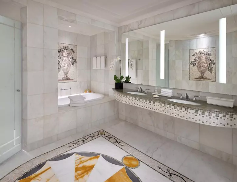 Elegant bathroom featuring marble flooring and a spacious illuminated mirror in Wellington.