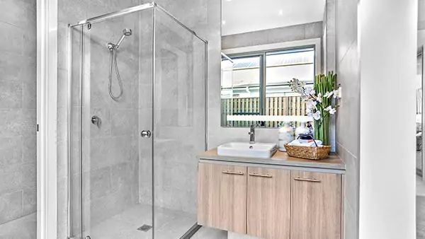 Compact of a bathroom featuring a glass shower room, and a sink with a lighted mirror in Melbourne.