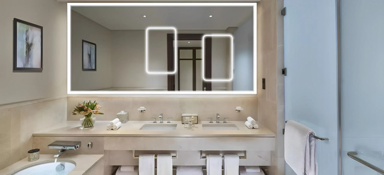 A bathroom featuring blue tiles and a mirror, creating a serene and modern atmosphere in Newcastle.