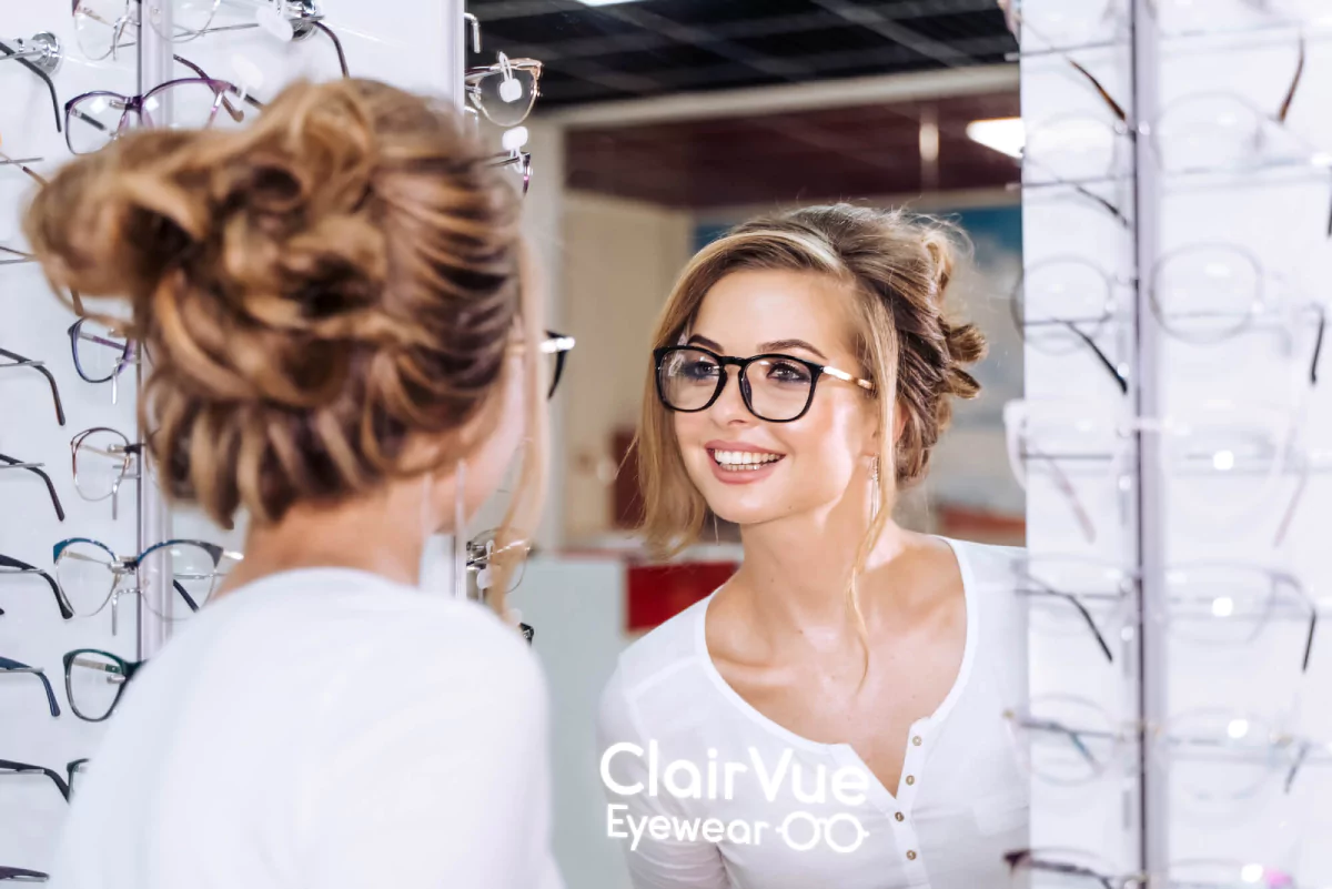 Female checking out glasses in a mirror featuring illuminated logo in Wellington.