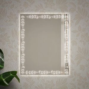 A paisley-designed light frame in a backlit mirror mounted on a wall.