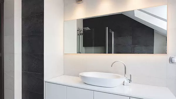 Bathroom with a sink and custom lighted mirror, featuring sleek design and clean lines in Wellington.