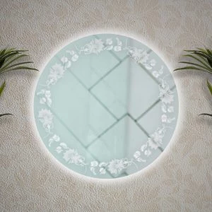 A paisley-designed light frame in a backlit circle-shaped mirror on a wall.