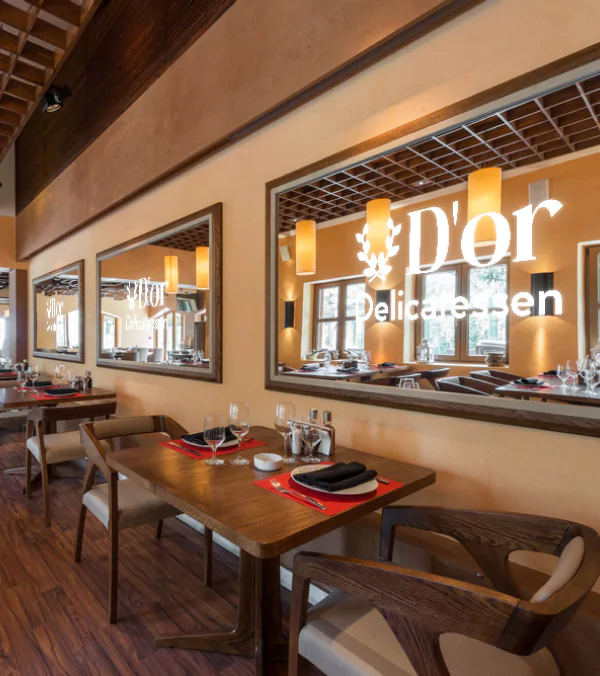 Compact of a restaurant with tables, chairs, and mirrors with a lit restaurant logo in Canberra.