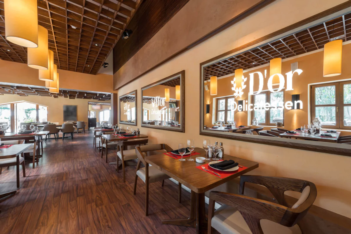 Restaurant with a wooden table, chairs, and large mirrors with a lit restaurant logo in Wellington.