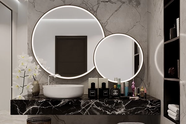 Two different sizes of round vanity LED mirrors mounted on a marble wall in Canberra.