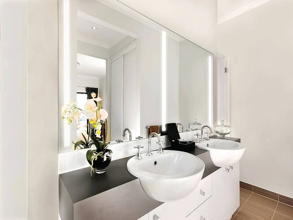 Well-lit bathroom with double-sink lighted mirror installed above sinks in Wellington.