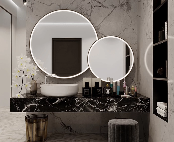 Modern bathroom design with marble walls and a circular custom lighted mirror in Wellington.