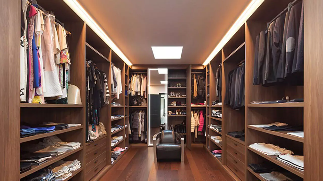 Interior of a walk in closet with wooden shelves and a luminous mirror in Melbourne.